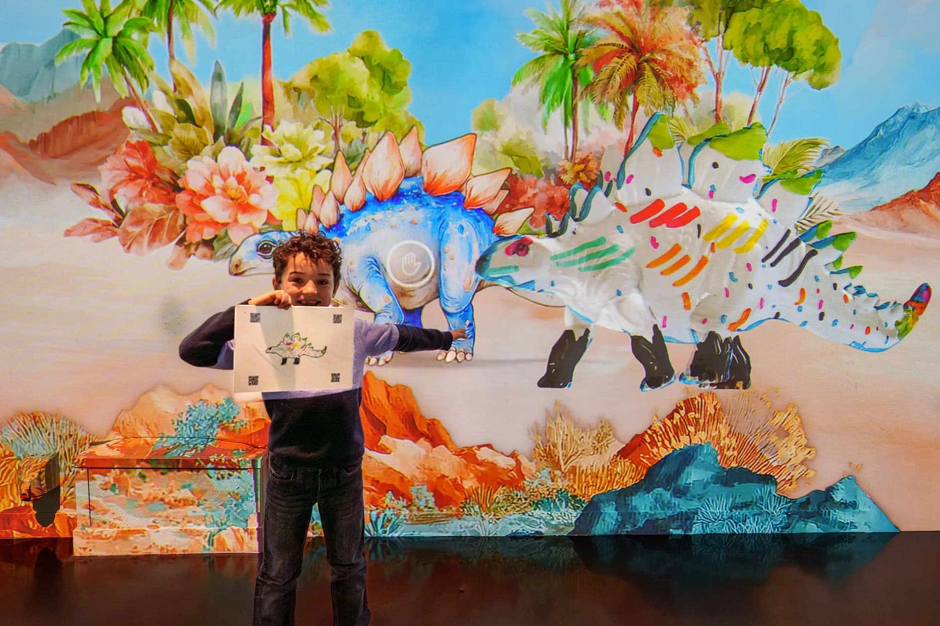 Enfant montrant son dessin devant la projection murale